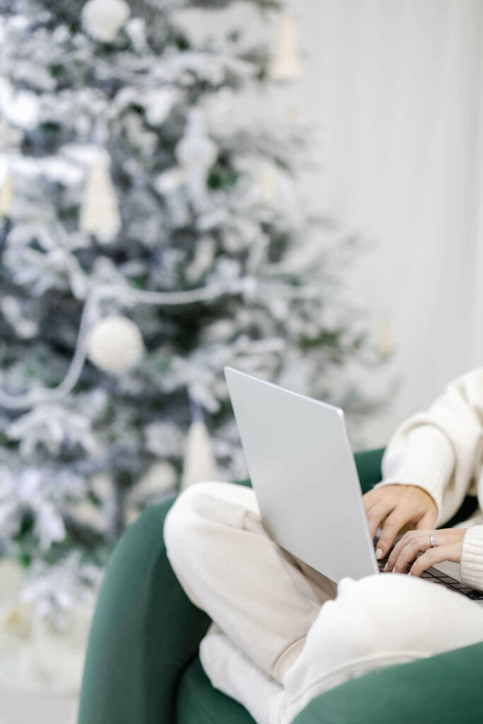 Web Designer Reviewing 2023 Sitting Next To Christmas Tree