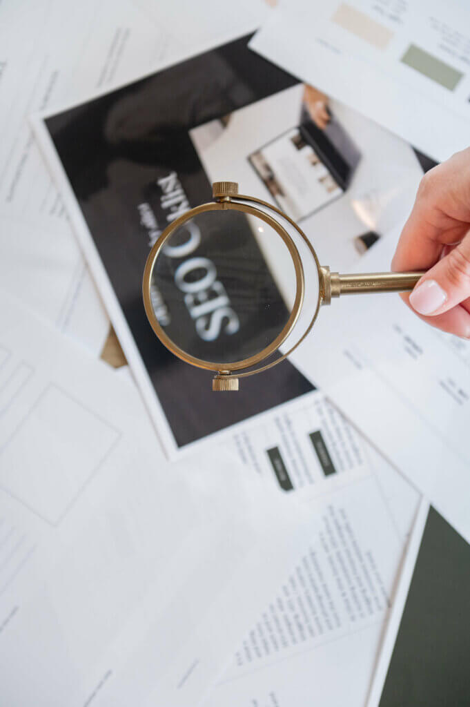 Image Of Southern Creative Owner, Stephanie O'Keefe, Holding A Magnifying Glass Over Seo Strategy Papers Helping Strategize How To Get Found Online With Seo.