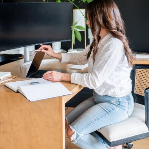 Wordpress And Seo Strategy Company Owner, Stephanie O'Keefe, Sitting At Desk In Raleigh, Nc.