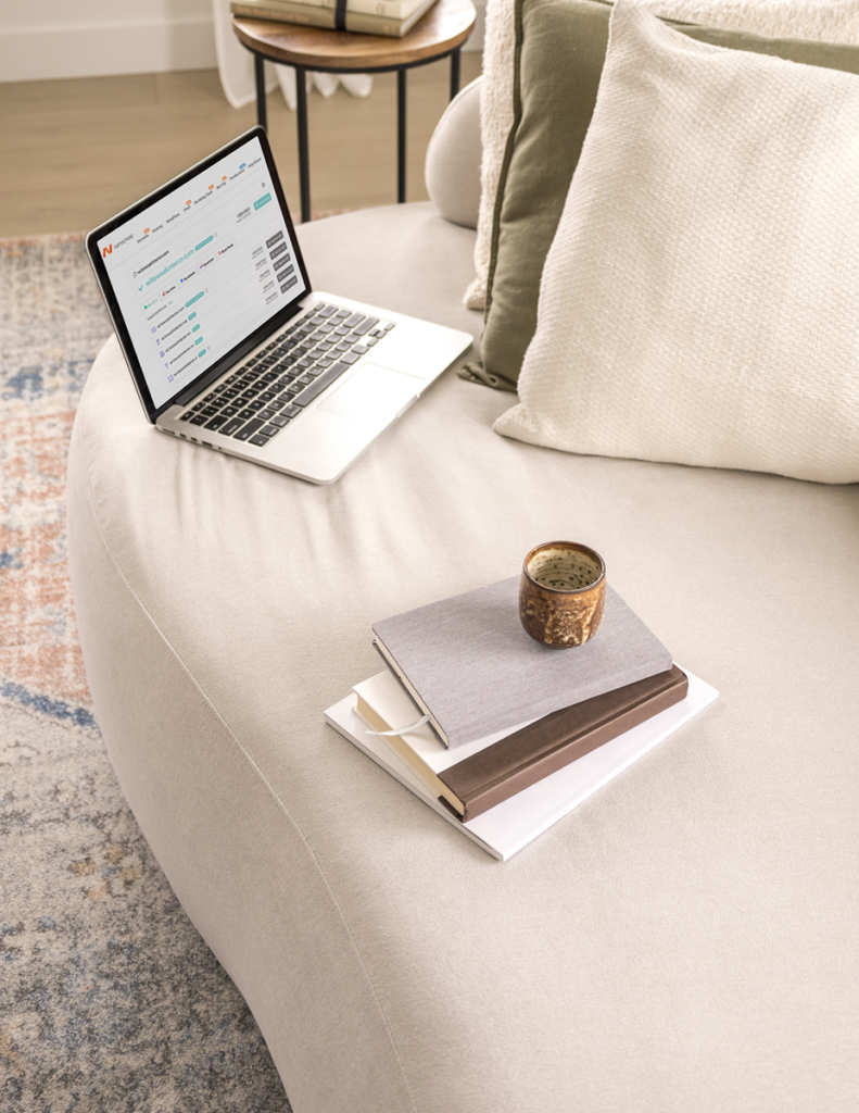 Image Of A Laptop With Domain Host, Namecheap, On A Couch In Interior Design Studio.