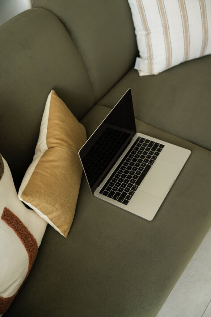 Laptop On Green Couch With Yellow Pillow