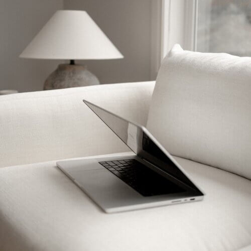 computer on white couch in interior design studio