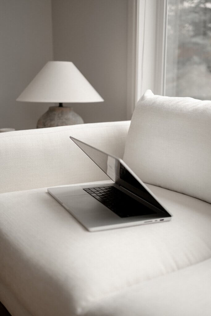 Computer On White Couch In Interior Design Studio