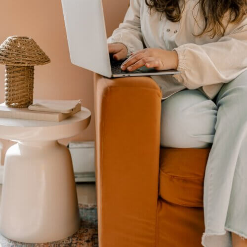 business owner typing at home on laptop