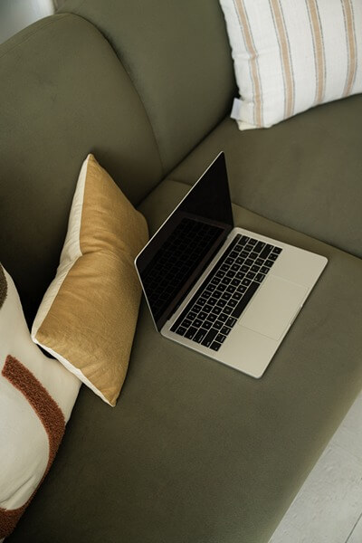 Implementing Idx Listings On Your Wordpress Website Laptop On Couch, Working On Idx On Wordpress Website