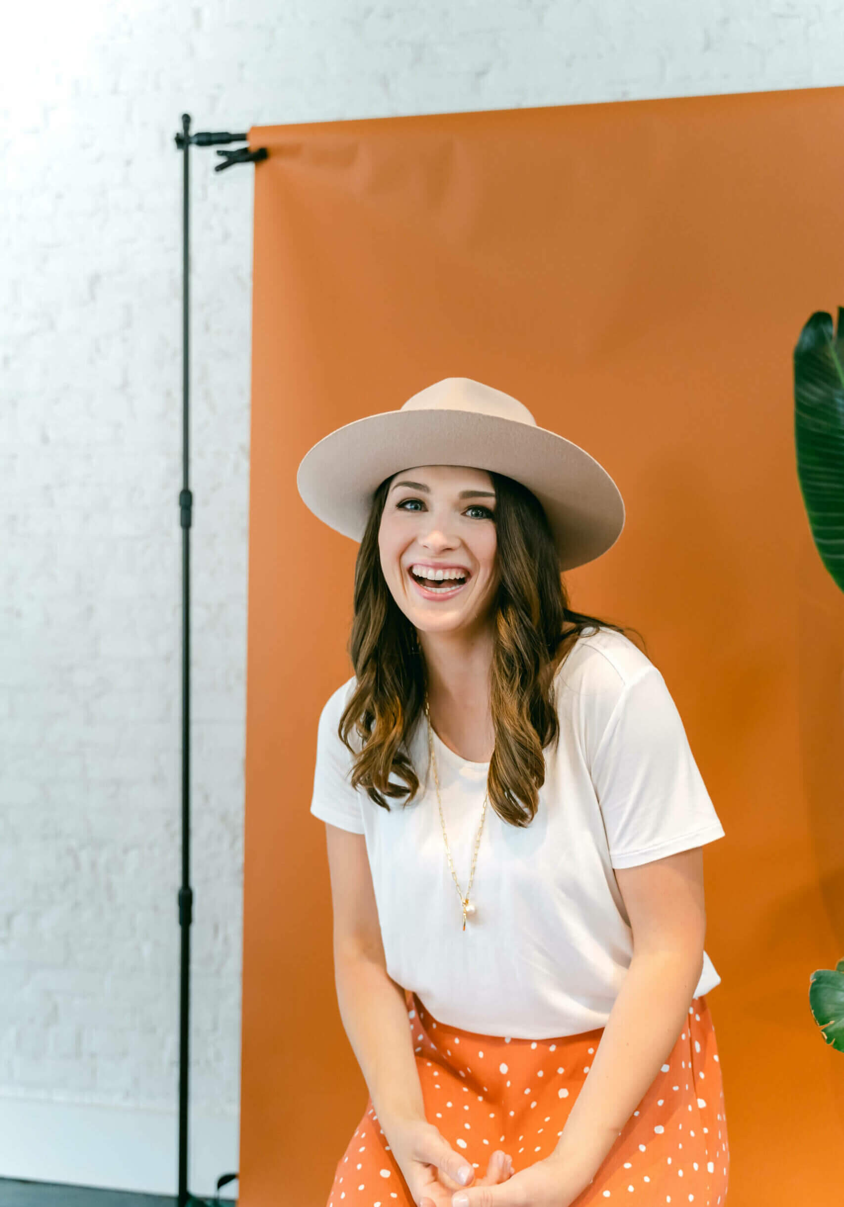 Southern Creative Owner And Wordpress Web Designer, Stephanie Okeefe In White Shirt And Orange Background.