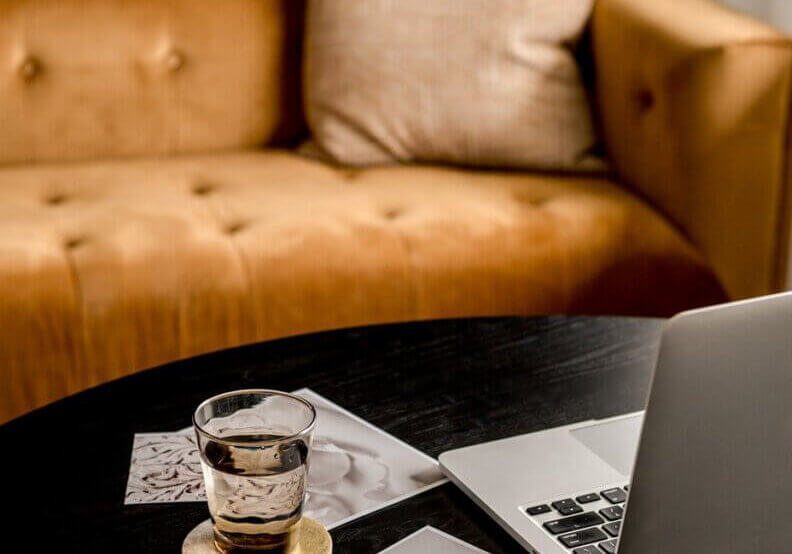 image of brown couch with laptop next to papers during meeting discussing Search Generative Experience.