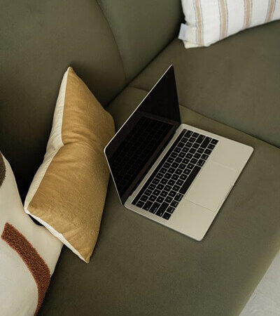 Laptop on couch, working on IDX on WordPress website