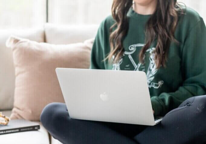 seo strategist sitting on couch typing on computer