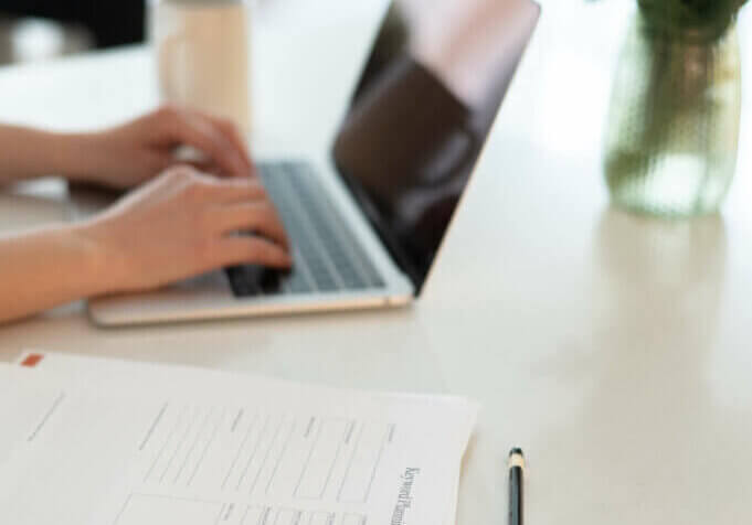 Stephanie O'Keefe SEO strategist working on Header Tag Optimization on laptop in kitchen.