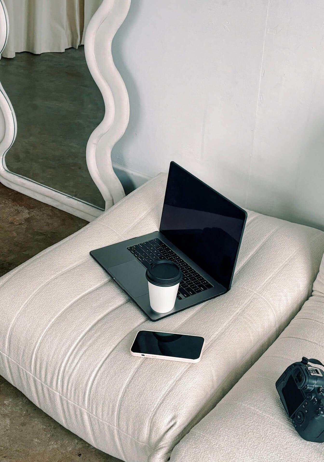 Laptop On White Couch With A Picture Of A Website Design For A Coach.