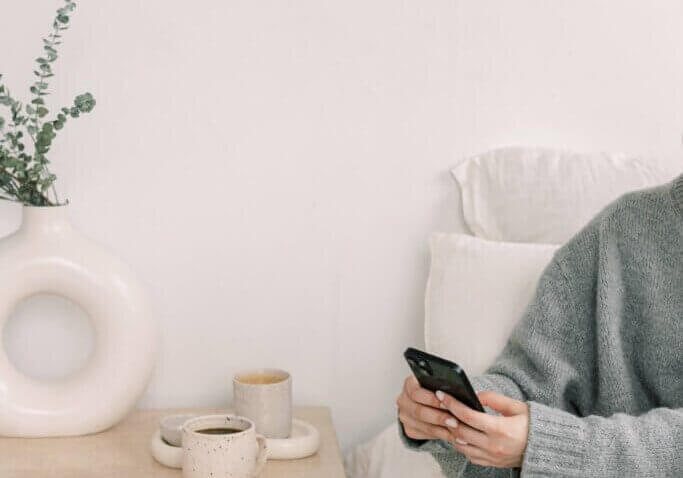 business owner reading phone in bed