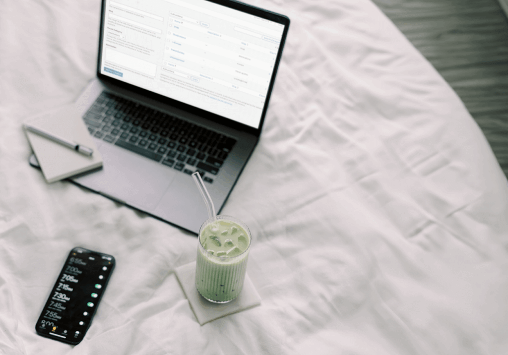 WordPress Categories vs. Tags on laptop on bed with matcha drink.