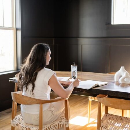 Stephanie O'Keefe working on SEO strategy for client's website and writing on notebook in home office